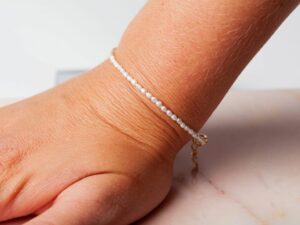 Vrouw met parel armband om pols Bracelet Pearl Riley 925 sterling zilver en 18K goud zoetwaterparel Laura Design