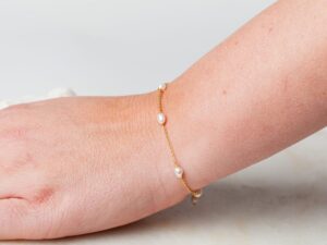 Vrouw met parel armband om pols Bracelet Pearl Amaya 925 sterling zilver en 18K goud & zoetwaterparel Laura Design