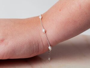 Vrouw met parel armband om pols Bracelet Pearl Amaya 925 sterling zilver en zoetwaterparel Laura Design